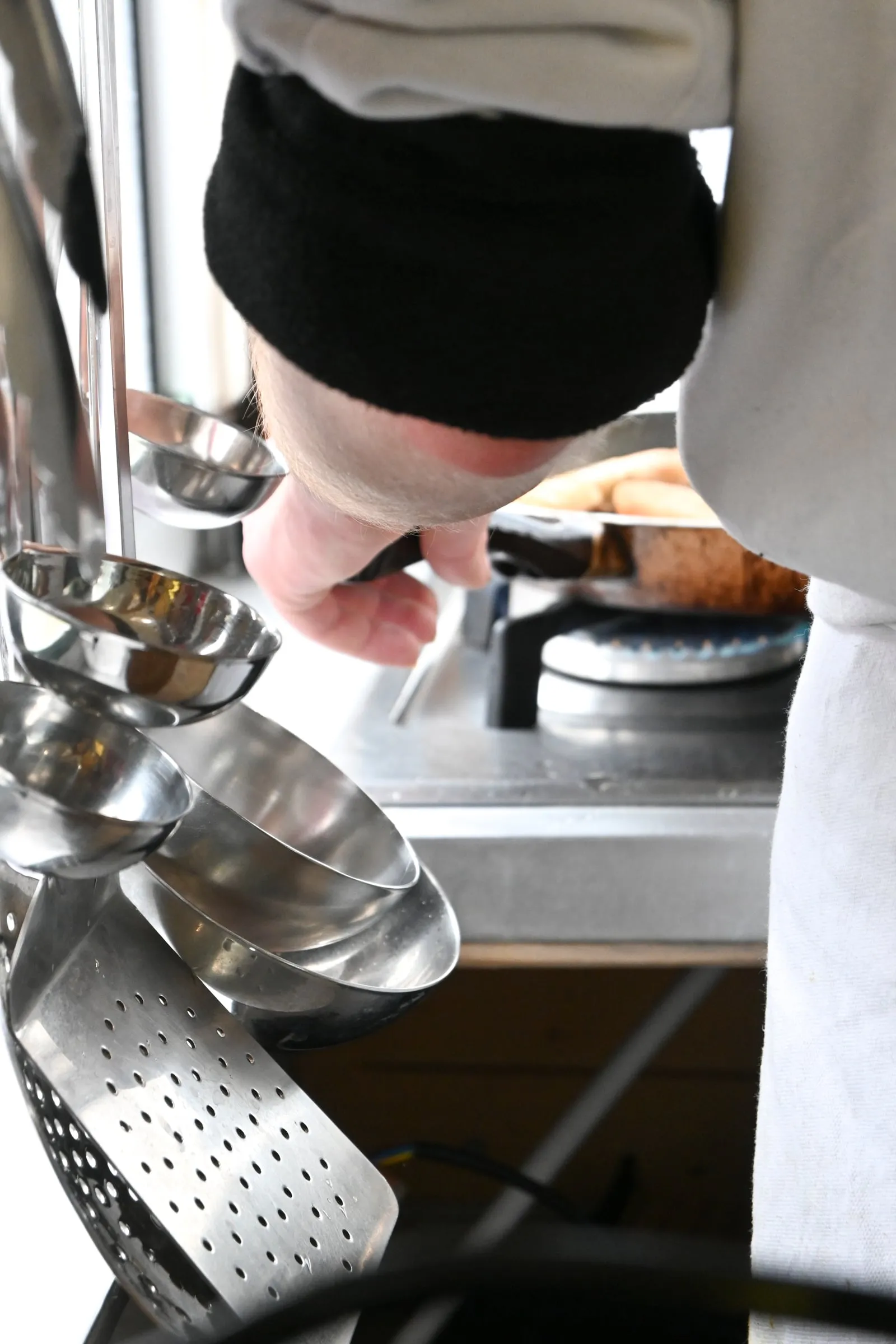 Un cuisinier du Bien Calé au piano, louches suspendues au premier plan